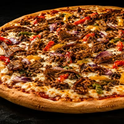 Pizza généreusement garnie de viande et de poivrons
