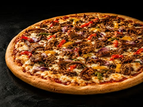 Pizza Spicy entière, garnie de merguez, kefta, piments et oignons rouges